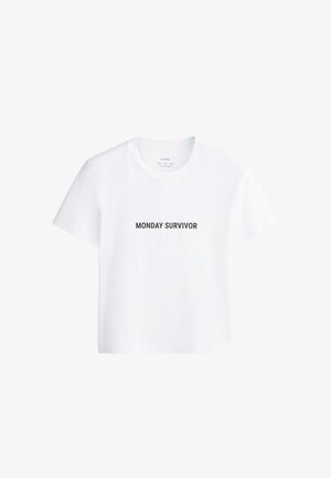 Wit T-shirt met korte mouwen, ronde hals en zwarte tekst "MONDAY SURVIVOR" centraal op de voorkant gedrukt.