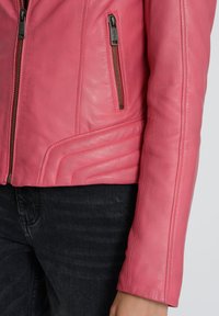 Fuchsia læderjakke med en tætsiddende design, skrå syninger og to lynlåslommer. Glat tekstur med minimal syning detaljer.