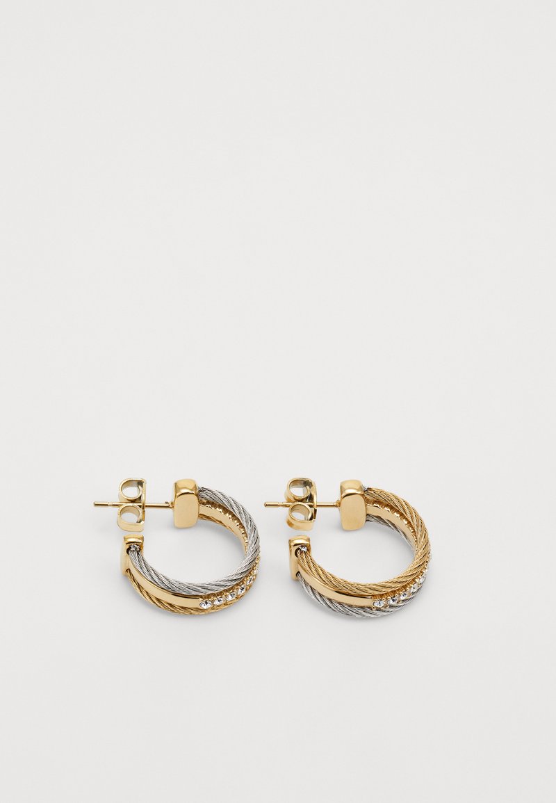 Orecchini a cerchio in oro e argento con texture intrecciata, caratterizzati da una combinazione di metallo liscio e attorcigliato, e una singola fila di pietre trasparenti.