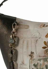 Braune und beige Lederhandtasche mit dekorativen Anhängern, darunter eine Katze und eine Münze, strukturierte Oberfläche und gestickte Muster von Säulen und Blättern.