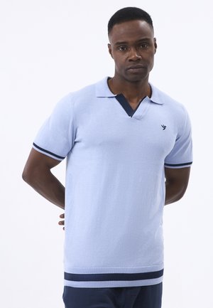 Lys blå strikket polo skjorte med en marineblå krave og ærmeaccenter, der har en slim fit og tekstureret stof. Minimalistisk logo på brystet.
