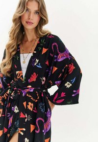 Černý kimono s výraznými květinovými a zvířecími vzory v purpurové, červené a zelené. Široké rukávy a zavazovací pásek zvýrazňují jeho uvolněný siluetu.