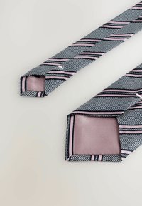 Cravate rayée bleu marine et rose avec des motifs géométriques. Tissu texturé avec un dos lisse de couleur rose uni. Fins pointus et bords contrastés.