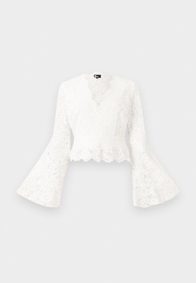 Witte kanten cropped jacket met klokmouwen, voorzien van een gegolfde zoom en een diepe V-hals. Zachte textuur met ingewikkelde bloemmotieven.
