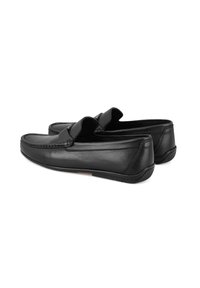 Schwarze Lederloafers mit glatter Textur, runder Zehenpartie und erhöhten Nahtdetails. Mit elastischen seitlichen Akzenten und Gummisohlen.