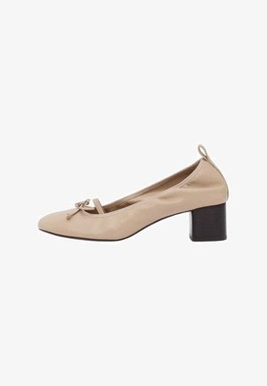 Beige leather women's pump with a low block heel, rounded toe, small bow detail on front, and pull tab at heel.