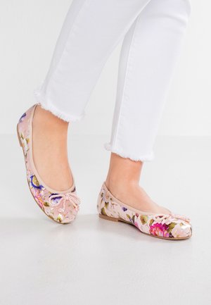 Różowe baleriny w kwiaty wykonane z miękkiej tkaniny, z zaokrąglonym noskiem i ozdobną kokardką z wstążki. Wzór przedstawia wielokolorowe kwiaty na jasnym tle.