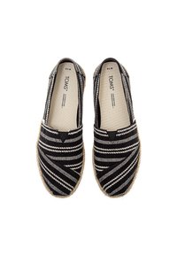 Black and white striped canvas espadrilles with a natural jute sole, featuring a slip-on design and elasticized side panels for comfort.