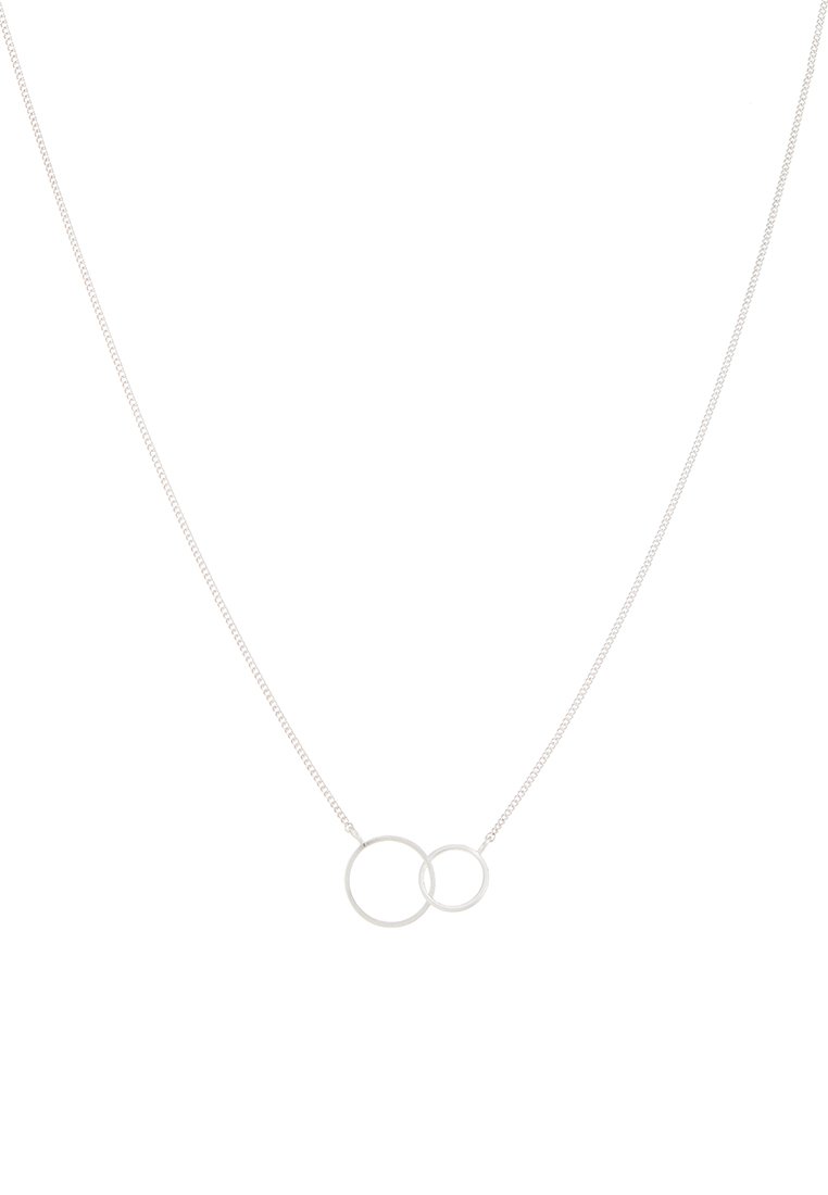 Collar de plata que presenta dos círculos entrelazados, uno más grande y otro más pequeño, en una cadena delgada. Textura suave con un diseño minimalista.