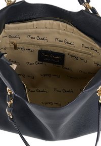 Sac à main en cuir noir avec une texture lisse, quincaillerie dorée et un intérieur doublé de tissu beige avec un motif de logo répétitif.