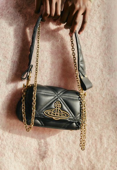 Sac à main en cuir matelassé noir avec une bandoulière en chaîne dorée et un détail de logo. Il présente une forme structurée et une texture lisse.