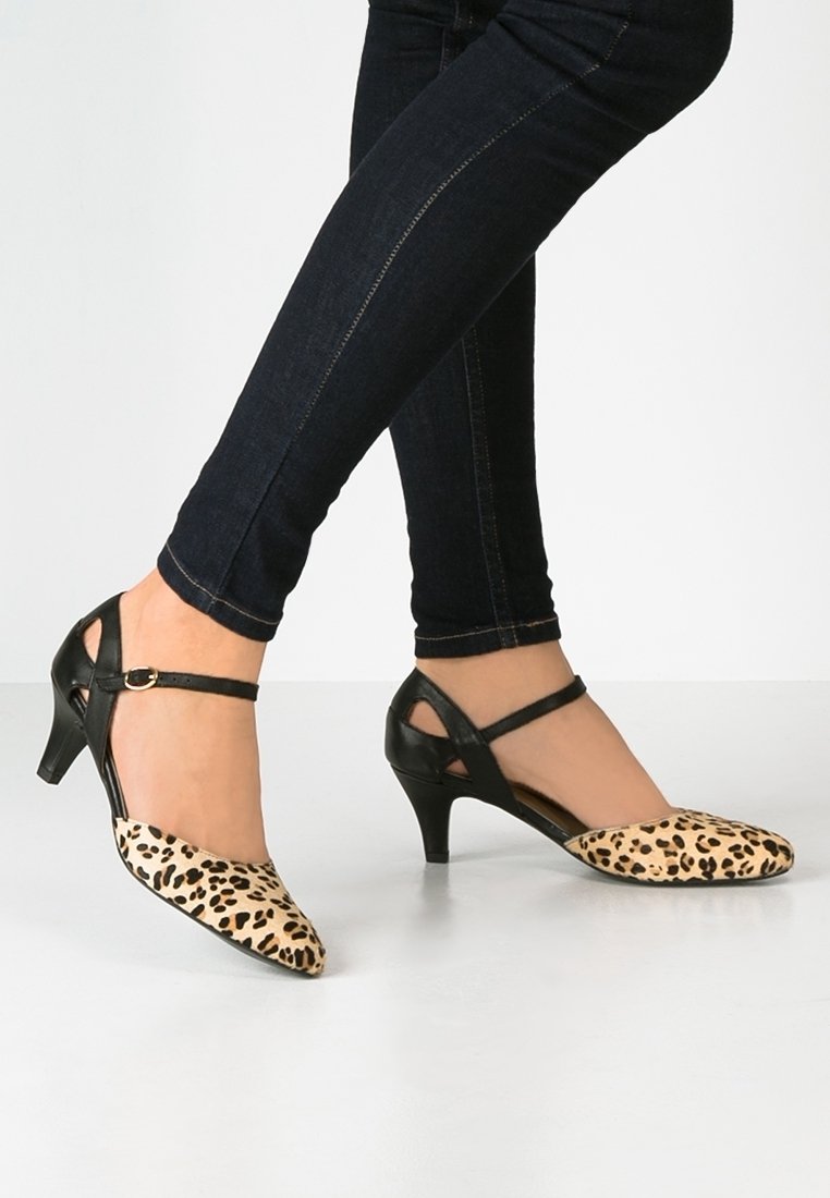 Escarpins à imprimé léopard avec accents en cuir noir, bout pointu et fine bride à la cheville, présentant un petit talon kitten.
