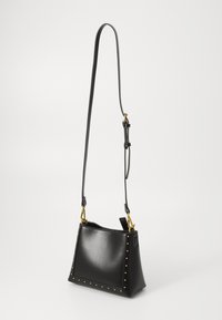 Sac en cuir noir au design structuré, avec des accents cloutés sur les bords, et une bandoulière amovible dotée de quincaillerie dorée.