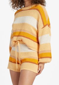 Brede twee-delige set met een losse, cropped trui en shorts in oranje en gele strepen met een gestructureerde afwerking en een tailleband met trekkoord.