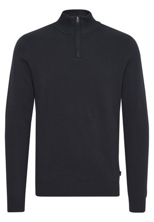 Crni pleteni pulover s visokim ovratnikom i četvrtastim patentnim zatvaračem. Rebrasti manžeti i rub, glatka tekstura i prilagođen dizajn.