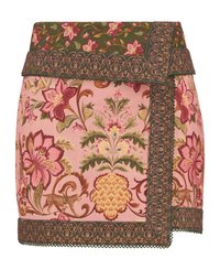 Mini-jupe brodée de fleurs en rose, avec des détails verts au niveau de la taille, ornée de motifs complexes et d'un ourlet festonné.