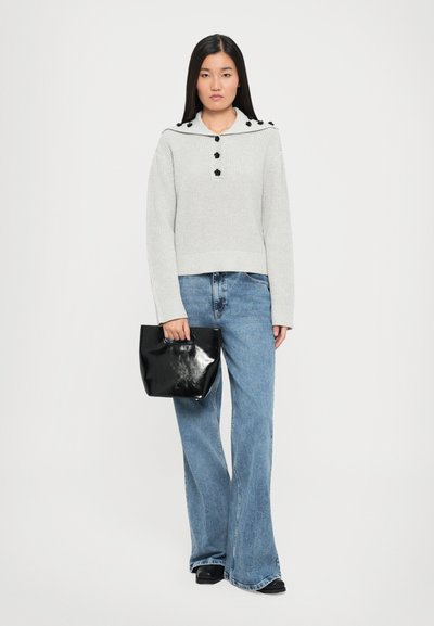 Pull gris à côtes avec détail de boutons noirs et col en forme de yoke, associé à un jean palazzo bleu clair et un sac à main noir brillant.