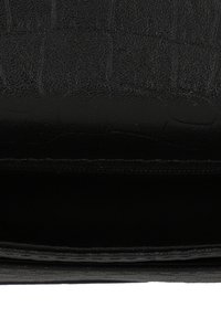 Czarna skórzana kopertówka o fakturowanym wykończeniu, z połyskującą powierzchnią i delikatnym wzorem przypominającym krokodyla. Centralne otwarcie bez detali metalowych.