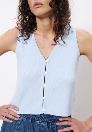 Un haut sans manches côtelé bleu clair avec un col en V et cinq boutons blancs sur le devant. Texture douce avec une coupe légèrement courte.