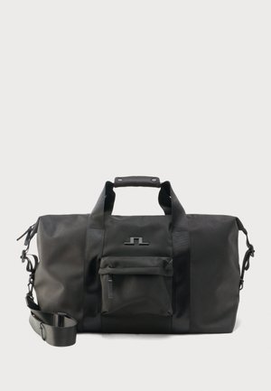 Czarna torba podróżna z podwójnymi uchwytami, regulowanym paskiem na ramię, przednią kieszenią na suwak i minimalistycznym logo na jednolitym tle.