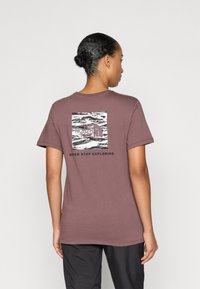 Bordeaux katoenen t-shirt met een ronde hals, met op de achterkant een zwart-wit grafische boxlogo en de tekst "NEVER STOP EXPLORING."