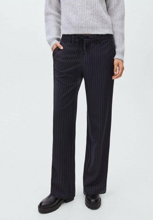 Pantaloni a gamba larga a righe navy realizzati in tessuto testurizzato, con vita elastica e coulisse, tasche laterali e abbinati a stivali neri.