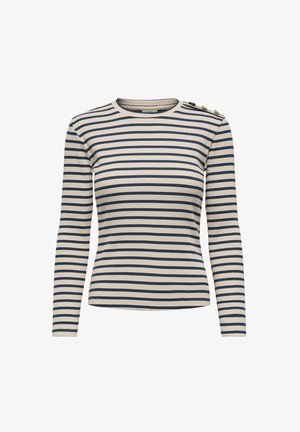 Dolga majica z rebrasto teksturo v kremni barvi z mornarsko modrimi vodoravnimi črtami. Ima gumbe kot okras na levem rami. Gladka tekstura.