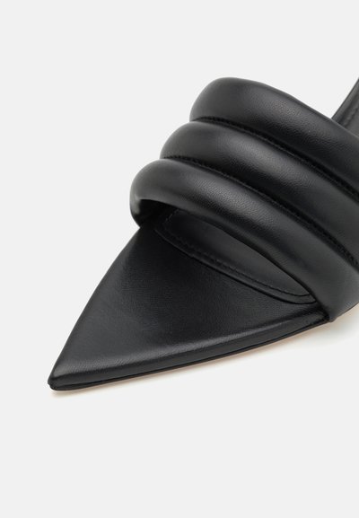 Sorte læder pejse-sandal med spidse tåer, der har tre polstrede remme for komfort og en glat tekstur, med syede detaljer langs kanterne.