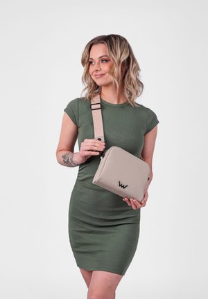 Béžová kabelka přes rameno s texturovaným materiálem, s černým logem a vzorovaným nastavitelným popruhem. Kompaktní obdélníkový tvar.