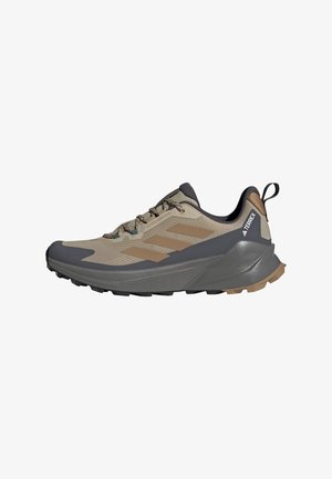 Beige and gray hiking shoe with mesh upper, textured rubber sole, and lacing system; features three striped accents on the side.