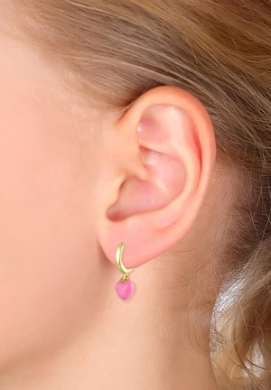 Guld hoops øreringe med en pink hjerte charm hænger fra loben. Charms har en glat, blank overflade og rund form.