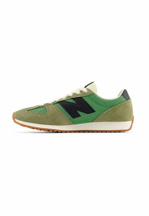 Grüner Sneaker aus Mesh und Veloursleder mit weißen Schnürsenkeln, schwarzem "N"-Logo an der Seite, weißer Zwischensohle und Gummiaußensohle.