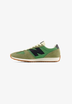 Grüner Sneaker aus Mesh und Veloursleder mit weißen Schnürsenkeln, schwarzem "N"-Logo an der Seite, weißer Zwischensohle und Gummiaußensohle.