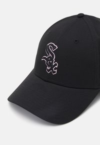 Casquette noire avec une visière incurvée ; présente un logo brodé en rose à l'avant. Fabriquée à partir d'un tissu à finition texturée.