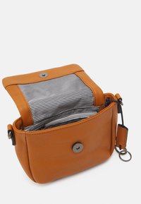 Kožená crossbody taška v hořčicově oranžové barvě se západkovým uzávěrem. Obsahuje pruhované vnitřní podšívku a vnější poutko na klíče.