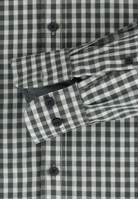 Groen en wit geruite blouse met een button-down kraag, voorzien van donkere knopen en contrasterende stiksels. Katoenen stof met een soepele textuur.