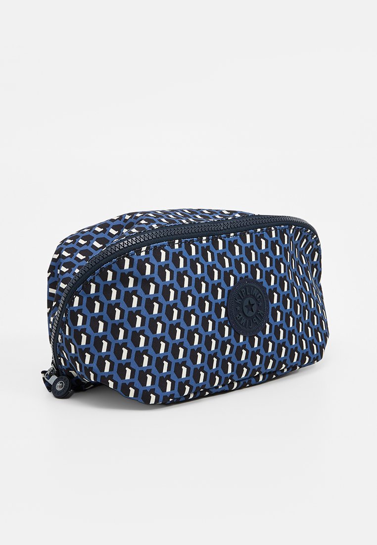 Trousse de maquillage à motifs bleus et navy avec fermeture éclair, en forme ovale, et un logo rond au centre. Fabriquée en tissu durable.