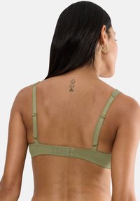 Olívazöld melltartó állítható pántokkal, sima textúrával, kampós-záródással és díszítő varrással a széleken.