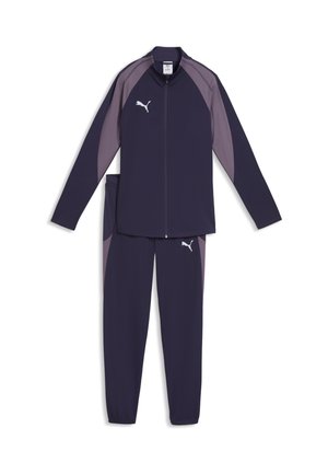 Chándal Puma en azul marino y gris con chaqueta con cremallera y pantalones con puño elástico, con el logo de Puma en el pecho y el muslo.