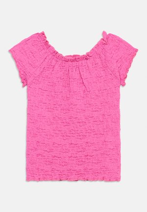 Lyserød kortærmet tekstureret top med rynket halsudskæring og flæsekant, lagt fladt på en hvid baggrund.