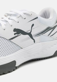 Hvide sportssko med en mesh-overdel, grå accenter og et fremtrædende Puma-logo. Har en polstret sål og en tekstureret ydersål for godt greb.