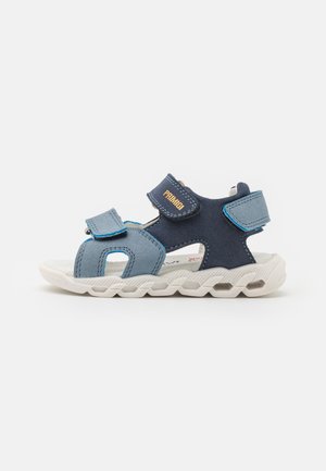 Sandali per bambini blu e blu scuro con cinturini in velcro, design con punta aperta e suola in gomma bianca testurizzata. Leggero imbottitura visibile all'interno.