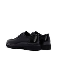 Zwarte leren schoenen met een gladde afwerking, een ronde neus en een verhoogde, gestructureerde zool. Voorzien van veters en gestikte accenten op het bovenwerk.