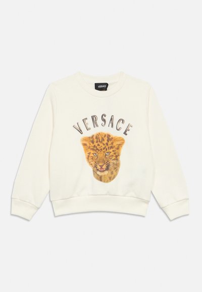 Sudadera cremosa de manga larga con texto "VERSACE" sobre un gráfico detallado de la cara de un cachorro de tigre en la parte frontal, con puños y dobladillo acanalados.