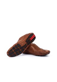 Braune Lederschuhe mit kunstvollen Nähten, niedrigem Profil, strukturiertem Obermaterial und schwarzen Gummisohlen, die rote Akzente und ein rutschfestes Muster aufweisen.