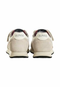 Sneaker in camoscio e pelle beige con design a basso profilo, caratterizzate da un logo sul tallone e una suola in gomma nera a contrasto.