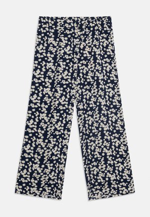 Pantalon large marine avec imprimé floral de marguerites blanches et jaunes partout, taille plate à l'avant et ourlet à la cheville.