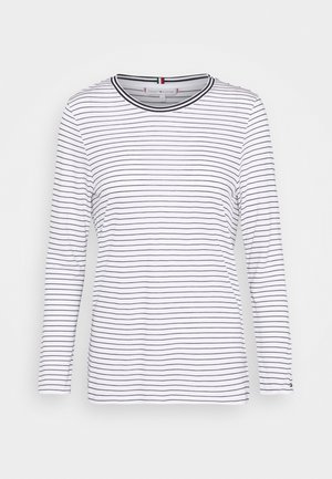 Wit langärmelig shirt met dunne zwarte horizontale strepen en zwarte bies rond de ronde halslijn, tentoongesteld op een effen achtergrond.