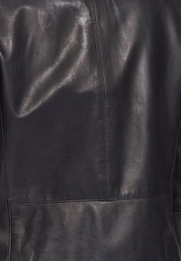 Zwarte leren jas met een gladde textuur, gestikte naden en een aansluitend ontwerp. Het oppervlak vertoont subtiele kreukels en een glanzende afwerking.