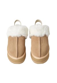 Een paar tan suède instapslippers met dikke witte fleece voering en lus-ophangtags aan de achterkant, gezien vanuit de top.